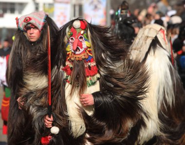 Pernik, Bulgaristan - 25 Ocak 2025: Bulgaristan 'ın Pernik kentinde düzenlenen 31. Uluslararası Maskeli Balo Festivali Surva. Kukeri adındaki maskeli insanlar dans ediyor ve kötü ruhları korkutmak için gösteri yapıyorlar..