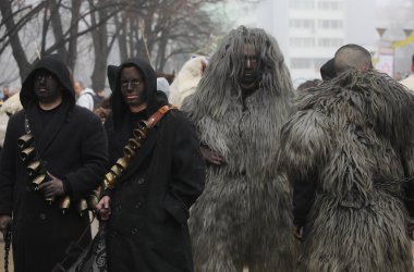 Pernik, Bulgaristan - 25 Ocak 2025: Bulgaristan 'ın Pernik kentinde düzenlenen 31. Uluslararası Maskeli Balo Festivali' ne geleneksel maskeler Urthos ve Buttudos Fonni 'yi sunan Kültür Derneği katıldı