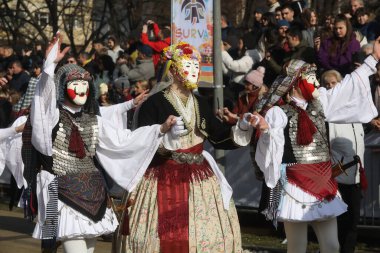 Pernik, Bulgaristan - 25 Ocak 2025: Maskeli balo grubu - Naoussa, Greecee Bulgaristan 'ın Pernik kentinde düzenlenen 31. Uluslararası Maskeli Balo Festivali' nde antik folklor geleneğini sundu
