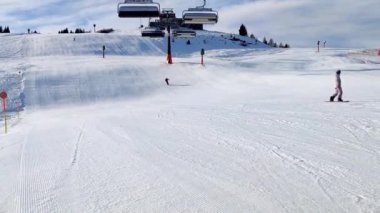 Waidring, Austria - 01.15.2023: View of skiers on the slopes, downhill skiing on an almost empty slope, beautiful weather