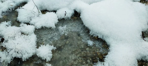 Avusturya Alplerinde donmuş bir nehir manzarası çatlak ve karlı buzun ayrıntıları, fotoğraf.