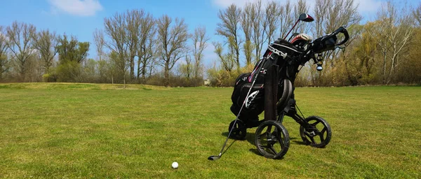 Ostrozska Nova Ves チェコ共和国 2023 ゴルフコースのカートにゴルフバッグ バッグに休んでいるゴルフクラブ ゴルフボール 木や青空を背景に — ストック写真