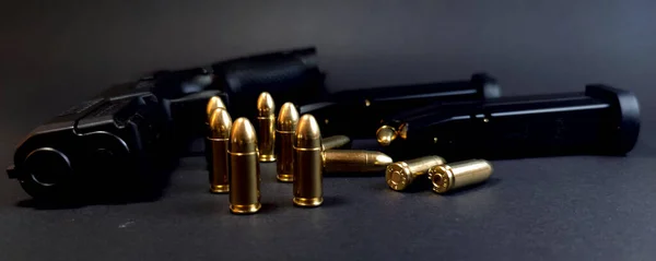 Gun and cartridges on a dark background, close-up of cartridges, photo
