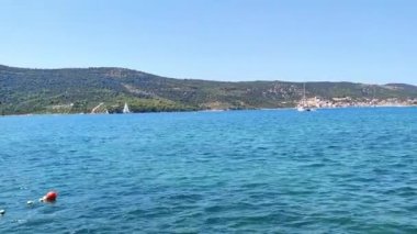 Hırvat denizi manzarası, arka plandaki yatlar demirli, dağ sırasının manzarası