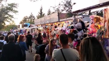 Uhersk Brod, Çek Cumhuriyeti - 30.09.2023: İnsanlar hac yolculuğunun arka planında atlıkarıncanın yanından geçiyor