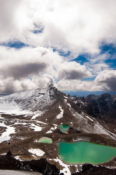 view of mountains, lakes and blue sky with white clouds in tongarino national park new zealand