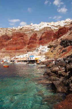 Oia, Santorini 'deki balıkçı evlerinin ve gemilerinin olduğu eski balıkçı limanının manzarası