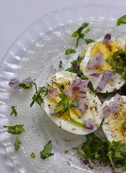 Haşlanmış yumurta, kıyılmış kişniş yaprakları ve çiğ soğanla süslenmiş. 