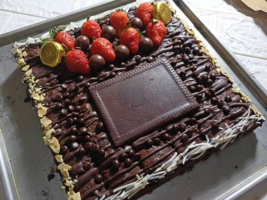 Üzerinde meyve ve yer olan çikolatalı brownie.