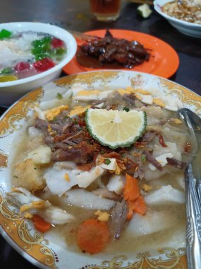 Soto Banjar The Table 'da sunuldu. Soto Banjar, Banjarmasin 'den geleneksel Endonezya tavuk çorbası. Endonezya.