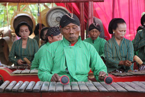 stock image old man wearing traditional javanese clothes playing gamelan music instrument. Yogyakarta, 15 September 2022