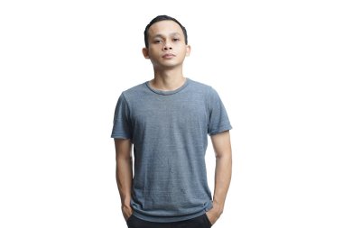 Tişört giyen genç yakışıklı bir adam. Yüzünde şüpheci ve gergin bir ifade var. Stüdyo arka planında izole