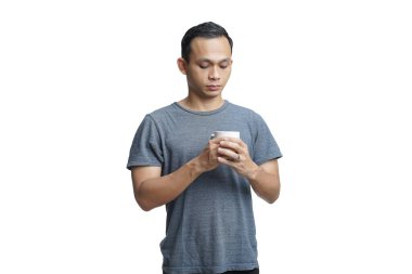 Yakışıklı Asyalı adam arka planda bir fincan kahve tutuyor.