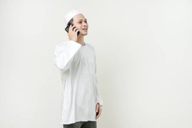 Mutlu Asyalı Müslüman adam telefon görüşmesi yapıyor. İnsanlar dini İslam yaşam tarzı kavramını benimsiyor. Ramazan ve Mübarek bayramını kutluyoruz. izole edilmiş arka grupta