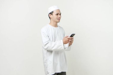 Cep telefonu tutan mutlu Müslüman adam. İnsanlar dini İslam yaşam tarzı kavramını benimsiyor. Ramazan ve Mübarek bayramını kutluyoruz. izole edilmiş arka grupta