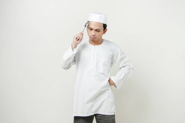 Müslüman adam kaşık tutuyor ve düşünme hareketi yapıyor. İnsanlar dini İslam yaşam tarzı kavramını benimsiyor. Ramazan ve Mübarek bayramını kutluyoruz. izole edilmiş arka grupta