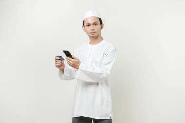 Yakışıklı Asyalı adamın kredi kartı ve cep telefonu var.