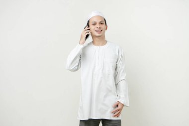 Mutlu Asyalı Müslüman adam telefon görüşmesi yapıyor. İnsanlar dini İslam yaşam tarzı kavramını benimsiyor. Ramazan ve Mübarek bayramını kutluyoruz. izole edilmiş arka grupta