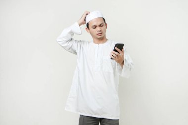  Elinde cep telefonu olan müslüman adam stresli ve hayal kırıklığına uğramış bir ifade takınıyor. İnsanlar dini İslam yaşam tarzı kavramını benimsiyor. Ramazan ve Mübarek bayramını kutluyoruz. izole edilmiş arka grupta