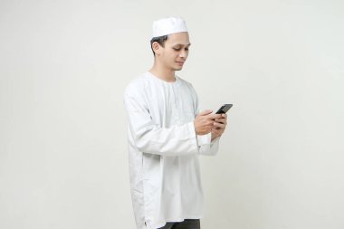 Cep telefonu tutan mutlu Müslüman adam. İnsanlar dini İslam yaşam tarzı kavramını benimsiyor. Ramazan ve Mübarek bayramını kutluyoruz. izole edilmiş arka grupta