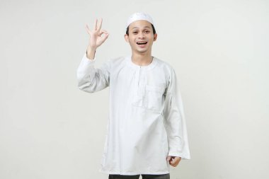 Mutlu Asyalı Müslüman adam el hareketi yapıyor. İnsanlar dini İslam yaşam tarzı kavramını benimsiyor. Ramazan ve Mübarek bayramını kutluyoruz. izole edilmiş arka grupta