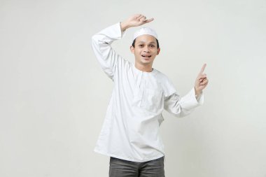 Mutlu Asyalı Müslüman adam parmak hareketi yapıyor. İnsanlar dini İslam yaşam tarzı kavramını benimsiyor. Ramazan ve Mübarek bayramını kutluyoruz. izole edilmiş arka grupta