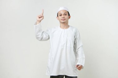 Mutlu Asyalı Müslüman adam parmak hareketi yapıyor. İnsanlar dini İslam yaşam tarzı kavramını benimsiyor. Ramazan ve Mübarek bayramını kutluyoruz. izole edilmiş arka grupta