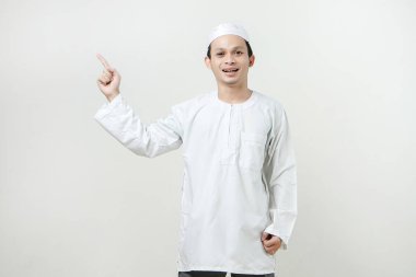 Mutlu Asyalı Müslüman adam parmak hareketi yapıyor. İnsanlar dini İslam yaşam tarzı kavramını benimsiyor. Ramazan ve Mübarek bayramını kutluyoruz. izole edilmiş arka grupta