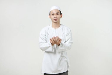 Dua eden eli olan Asyalı Müslüman adam. Avuç içlerini yukarıda tutarak. İnsanlar dini İslam yaşam tarzı kavramını benimsiyor. Ramazan ve Mübarek bayramını kutluyoruz. izole edilmiş arka grupta