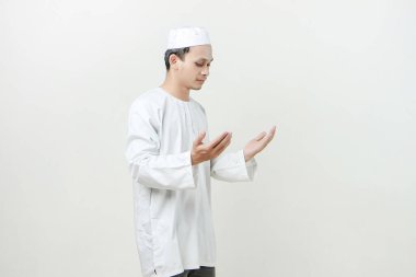 Dua eden eli olan Asyalı Müslüman adam. Avuç içlerini yukarıda tutarak. İnsanlar dini İslam yaşam tarzı kavramını benimsiyor. Ramazan ve Mübarek bayramını kutluyoruz. izole edilmiş arka grupta