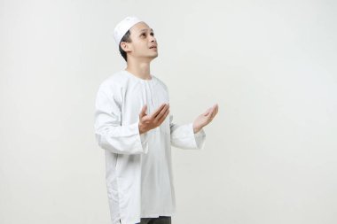 Dua eden eli olan Asyalı Müslüman adam. Avuç içlerini yukarıda tutarak. İnsanlar dini İslam yaşam tarzı kavramını benimsiyor. Ramazan ve Mübarek bayramını kutluyoruz. izole edilmiş arka grupta