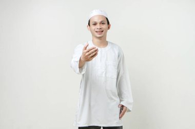 Mutlu Asyalı Müslüman adam el sıkışma hareketi yapıyor. İnsanlar dini İslam yaşam tarzı kavramını benimsiyor. Ramazan ve Mübarek bayramını kutluyoruz. izole edilmiş arka grupta