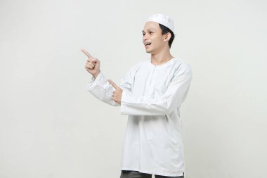 Mutlu Asyalı Müslüman adam parmak hareketi yapıyor. İnsanlar dini İslam yaşam tarzı kavramını benimsiyor. Ramazan ve Mübarek bayramını kutluyoruz. izole edilmiş arka grupta