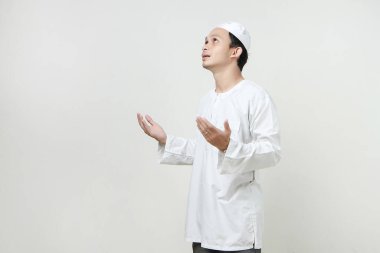 Dua eden eli olan Asyalı Müslüman adam. Avuç içlerini yukarıda tutarak. İnsanlar dini İslam yaşam tarzı kavramını benimsiyor. Ramazan ve Mübarek bayramını kutluyoruz. izole edilmiş arka grupta