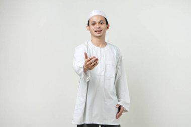 Mutlu Asyalı Müslüman adam el sıkışma hareketi yapıyor. İnsanlar dini İslam yaşam tarzı kavramını benimsiyor. Ramazan ve Mübarek bayramını kutluyoruz. izole edilmiş arka grupta