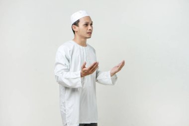 Dua eden eli olan Asyalı Müslüman adam. Avuç içlerini yukarıda tutarak. İnsanlar dini İslam yaşam tarzı kavramını benimsiyor. Ramazan ve Mübarek bayramını kutluyoruz. izole edilmiş arka grupta