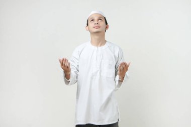 Dua eden eli olan Asyalı Müslüman adam. Avuç içlerini yukarıda tutarak. İnsanlar dini İslam yaşam tarzı kavramını benimsiyor. Ramazan ve Mübarek bayramını kutluyoruz. izole edilmiş arka grupta