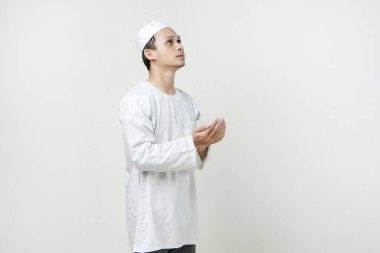 Dua eden eli olan Asyalı Müslüman adam. Avuç içlerini yukarıda tutarak. İnsanlar dini İslam yaşam tarzı kavramını benimsiyor. Ramazan ve Mübarek bayramını kutluyoruz. izole edilmiş arka grupta