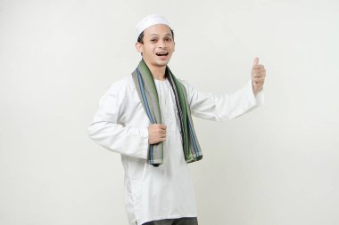 Asyalı Müslüman adam baş parmağını kaldırdı. İnsanlar dini İslam yaşam tarzı kavramını benimsiyor. Ramazan ve Mübarek bayramını kutluyoruz. izole edilmiş arka grupta