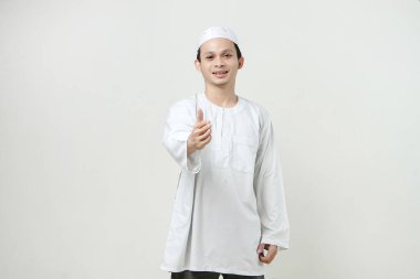 Mutlu Asyalı Müslüman adam el sıkışma hareketi yapıyor. İnsanlar dini İslam yaşam tarzı kavramını benimsiyor. Ramazan ve Mübarek bayramını kutluyoruz. izole edilmiş arka grupta