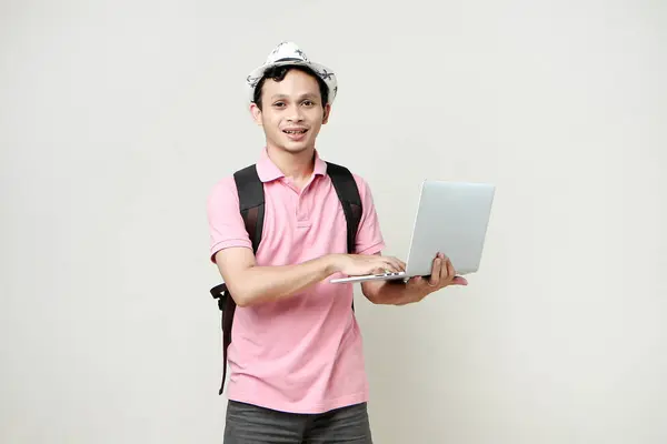 Asian man backpacker holding laptop computer. digital nomad and travelling concept. on isolated background