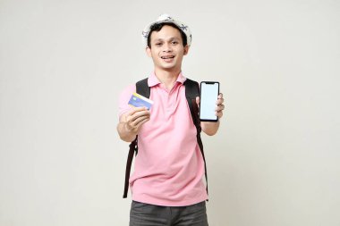 Cep telefonu ve kredi kartı taşıyan Asyalı bir sırt çantalı. Dijital göçebe ve seyahat konsepti. izole edilmiş arkaplanda