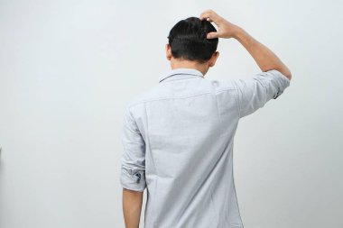 Asyalı Endonezyalı adamın el ele tutuşup stres dolu, kafası karışık bir hareket göstermesi. izole arkaplan