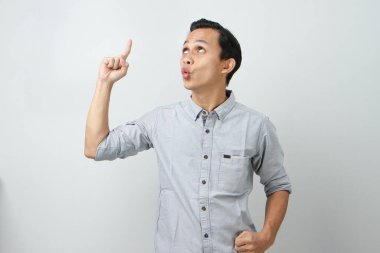 Mutlu, neşeli Asyalı Endonezyalı adam ifadesi izole edilmiş arka planda parmağını yukarı kaldırıyor.