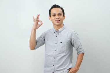 Neşeli, mutlu, kendine güvenen Endonezyalı, izole edilmiş arka planda parmak hareketi yapan.