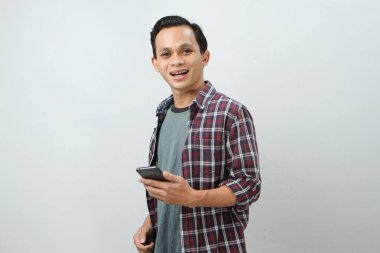 Akıllı telefon tutan mutlu Asyalı Endonezyalı adam. izole edilmiş arkaplanda