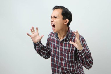 İzole edilmiş arka planda parmak hareketi yapan kızgın Asyalı adam.