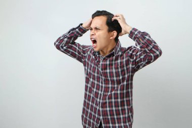 İzole edilmiş arka planda parmak hareketi yapan kızgın Asyalı adam.