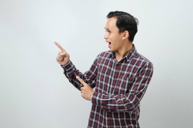 Mutlu Asyalı Endonezyalı adam izole edilmiş arka planda parmak işareti yapıyor.