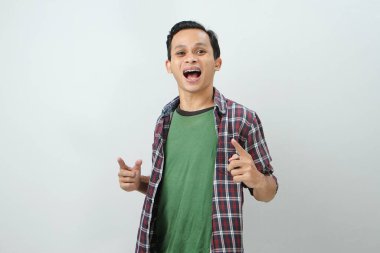 Mutlu Asyalı Endonezyalı adam izole edilmiş arka planda parmak işareti yapıyor.